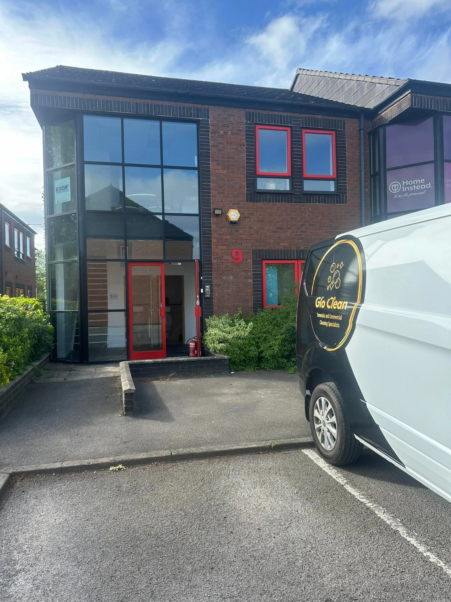 Glo Clean van outside red-trimmed brick office building with glass entrance, York commercial cleaning company