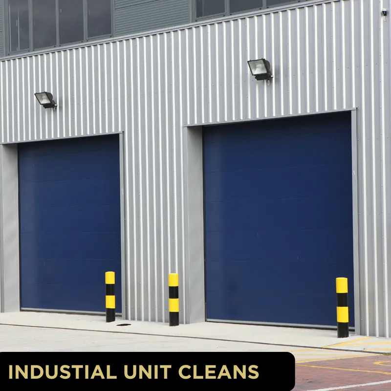 York industrial unit exterior showing corrugated metal cladding, two blue roller doors and yellow-black safety bollards